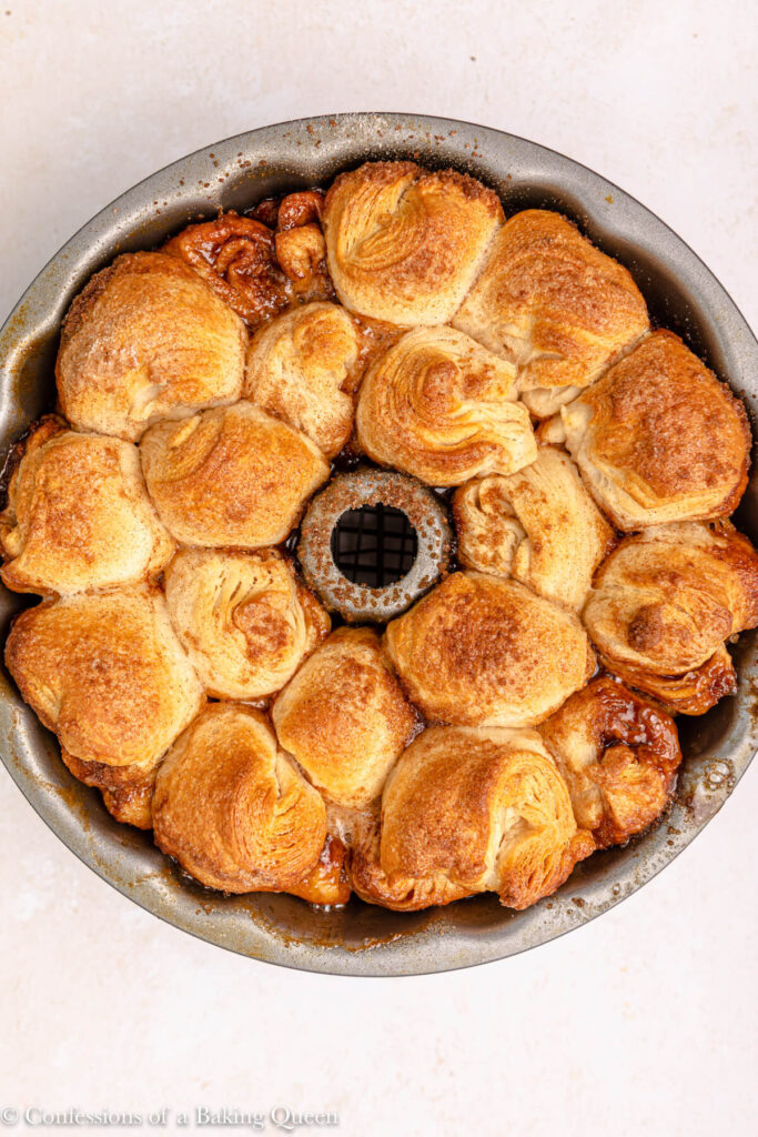 monkey bread fresh out of the oven cooling on a wire rack  on a light pink surface