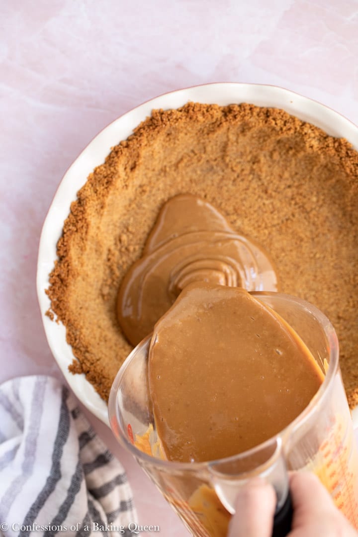 dulce de leche being poured into a graham cracker crust for a banoffee pie recipe