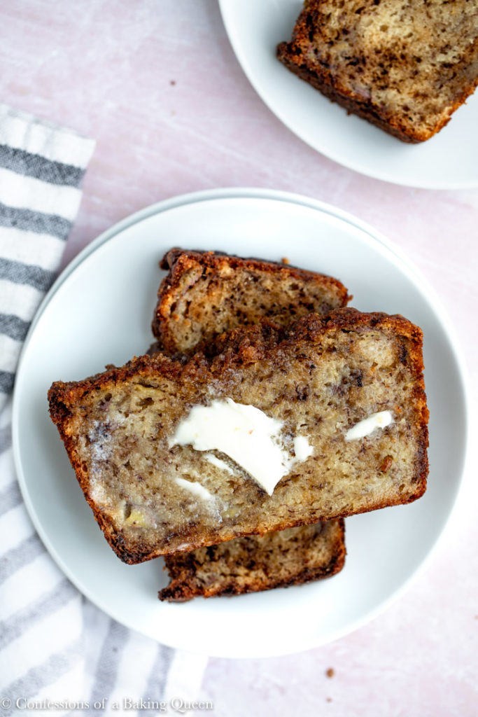 banana bread slices on a white plate with butte melting on the bread