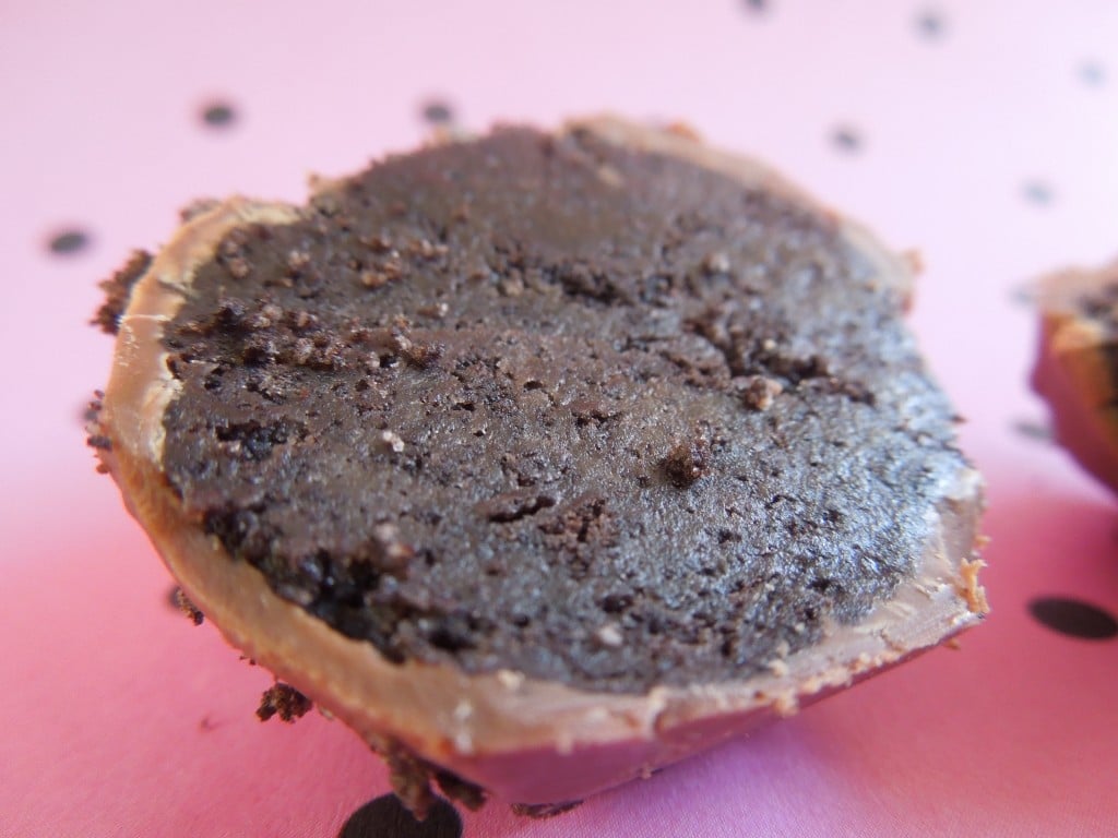 close up of oreo truffle cut in half on a pink background