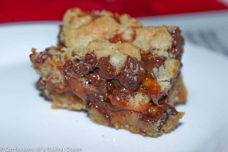 Salted Caramel Stuffed Chocolate Chip Cookie Bar on a white plate with a red background