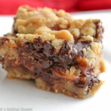 Salted Caramel Heath Bar Stuffed Chocolate Chip Cookie Bar on a white plate on a red tablecloth