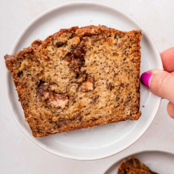 hand holding cookie butter banana bread slice up to the camera