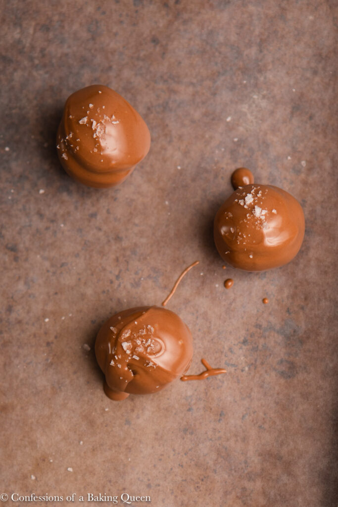 close up of sea salt chocolate truffles on a wax lined baking sheet
