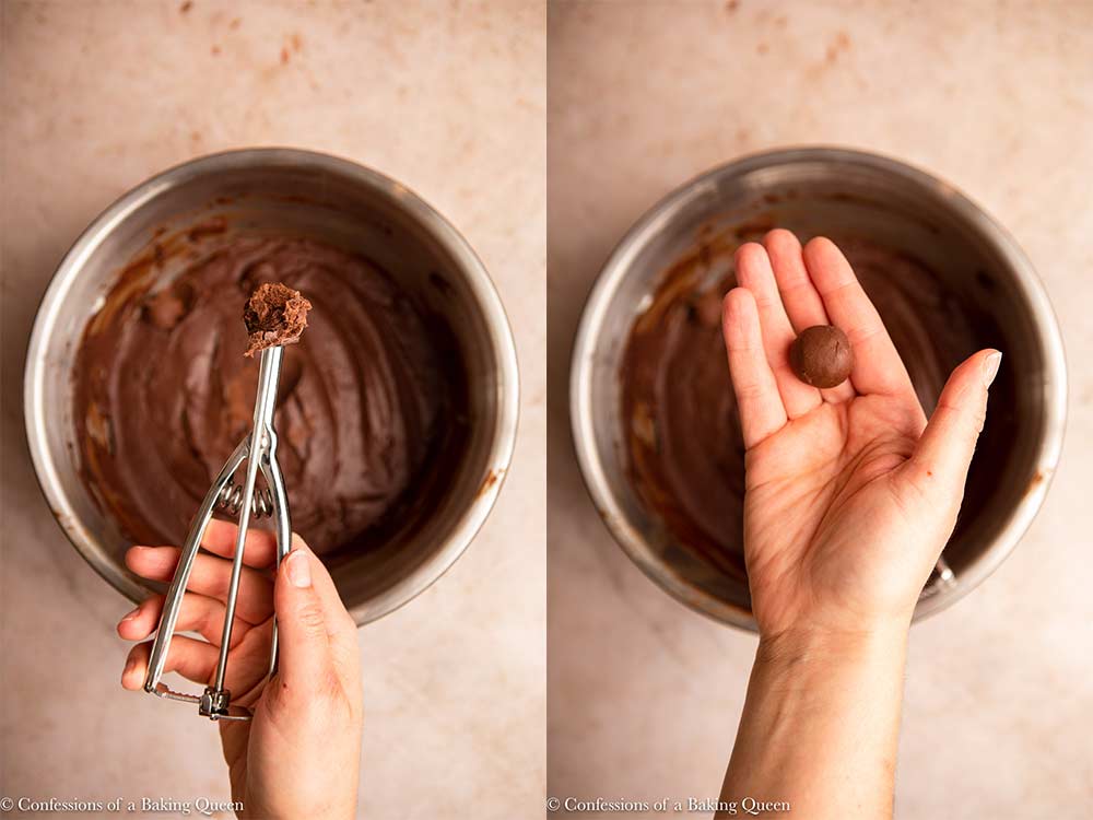 hand scooping and rolling chocolate truffles over a bowl of chocolate truffle mixture on a light brown surface