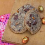 Butterfinger Egg & Pretzel Cookies baked and sitting on a wood board with a pink tea towel underneath
