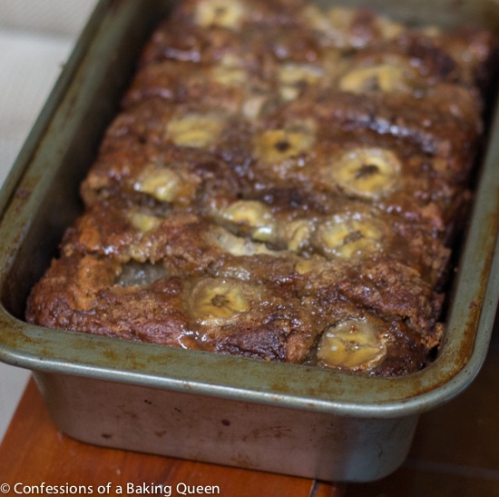 Bananas Foster Banana Bread in a metal loaf pan on a wood table