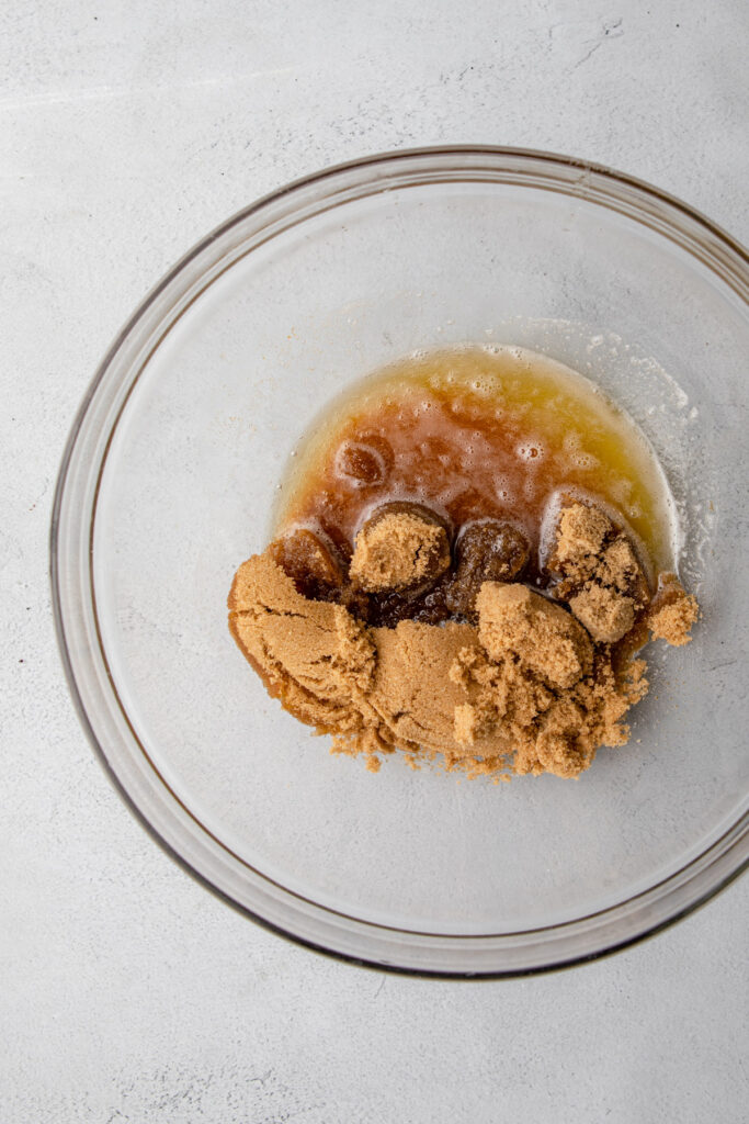 brown sugar and brown butter in a glass bowl on a grey surface (