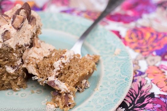 Coffee Heath Bar Crunch Cake piece with a fork bite on a blue plate on top of a pink and purple floral linen