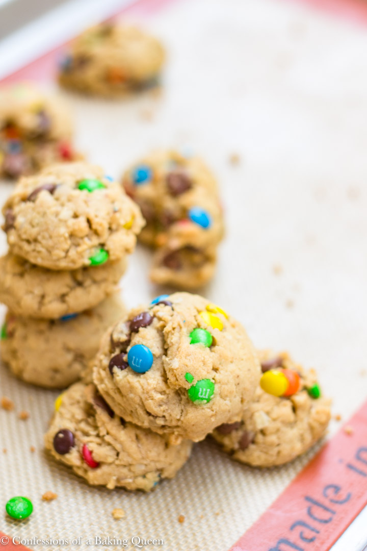 Brown Butter Oat & M&M Cookies baked and stacked on top of each other on a silpat liner