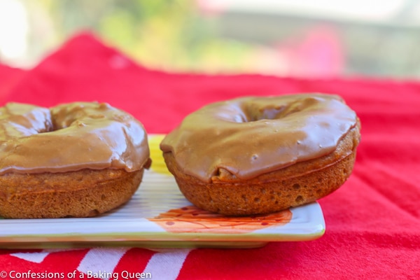 Maple Glazed Pumpkin Donuts on a plate on a red tea towel 