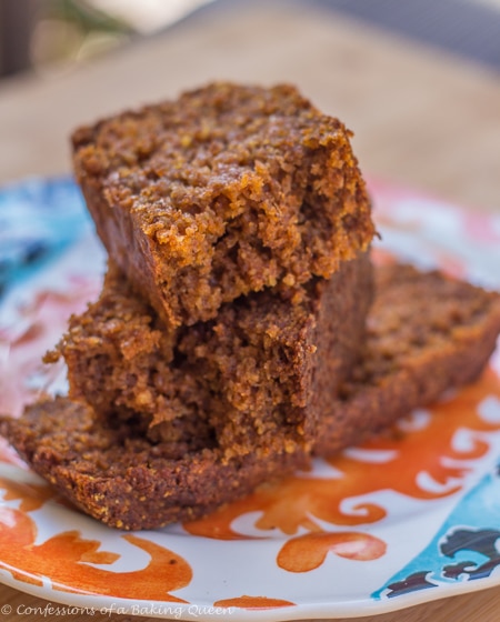 Oat Flour Pumpkin Bread Pieces stacked on top of each other on a colorful plate on a wood board