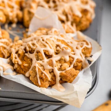 tray of pumpkin muffins on a wire rack on a grey surface with a knife