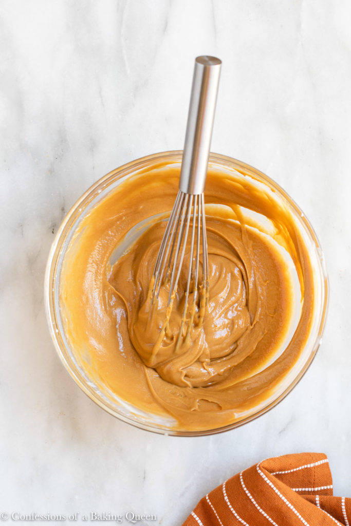cookie butter glaze in a glass bowl with a wire whisk