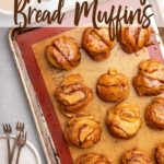 apple monkey bread muffins on a silpat lined sheet pan next to a cup of coffee and stack of plates and forks