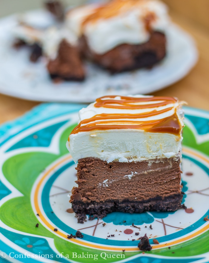 Salted Caramel Chocolate Cheesecake Bar on a blue and green plate with more bars in the background