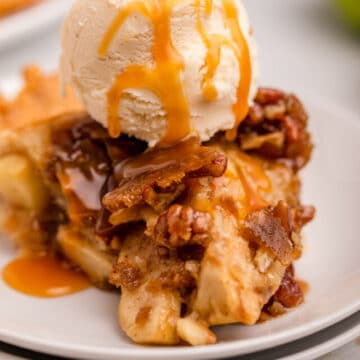 slice of salted caramel upside down apple pie with ice cream on a white plate