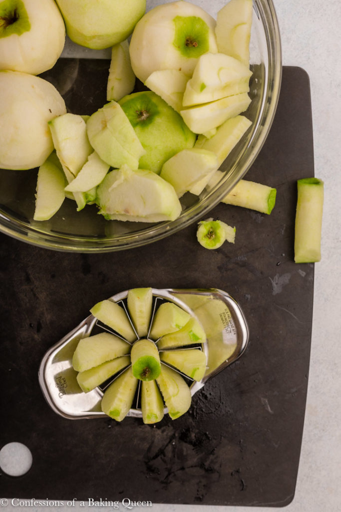 green apples peeled and sliced on a black cutting board