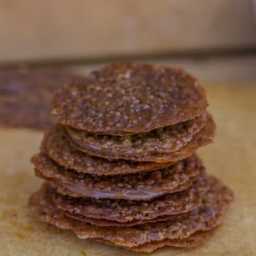 pecan laceys filled with milk chocolate stacked high on wood surface