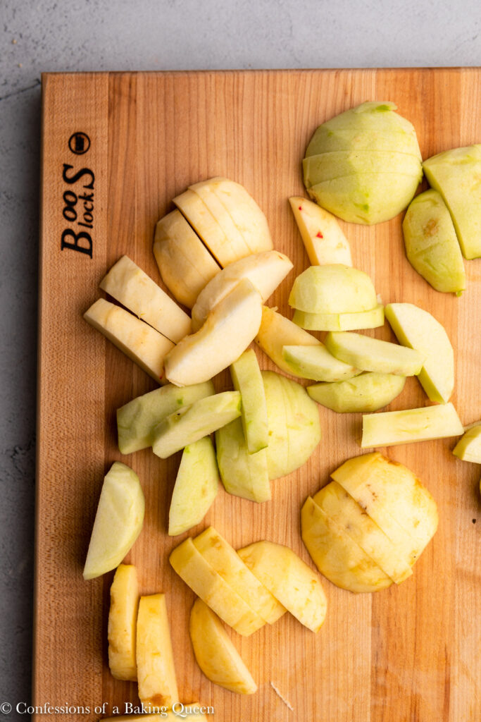 apples peeled and chopped into slices on a wood cutting board