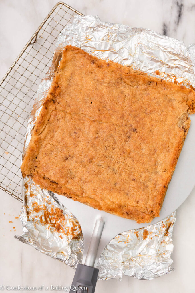 large spatula moving cookie bars from foil to a serving plate
