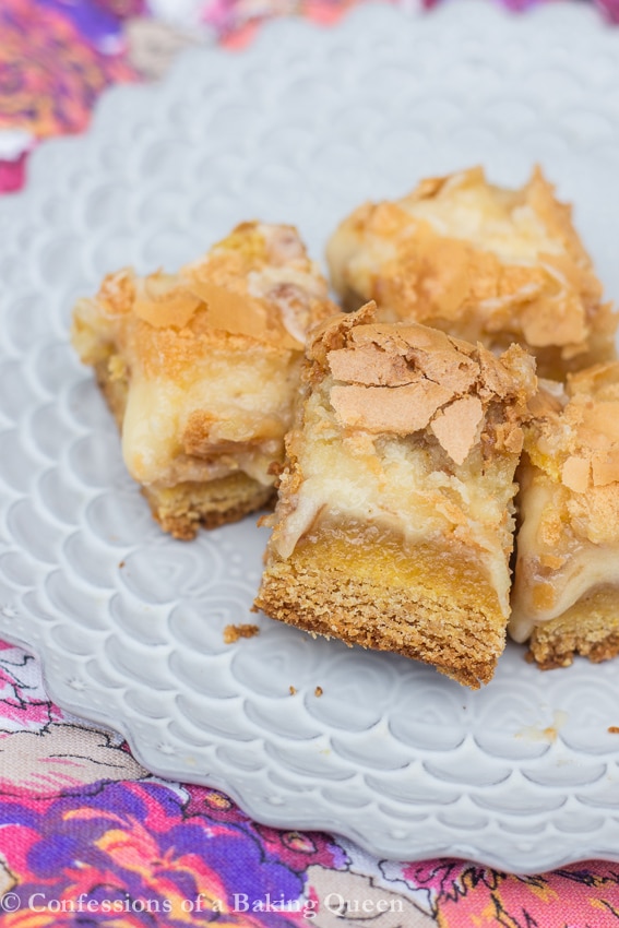 Brown Butter Toffee Gooey Cake Bars on a purple plate on top of a floral colorful tea towel