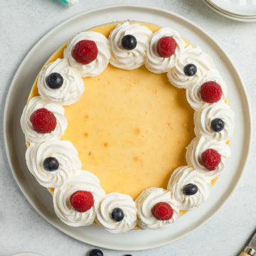 vanilla bean cheesecake with whipped cream and fresh berries