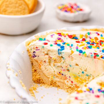 golden oreo cake batter pie cut open in a light purple pie dish on a white marble surface