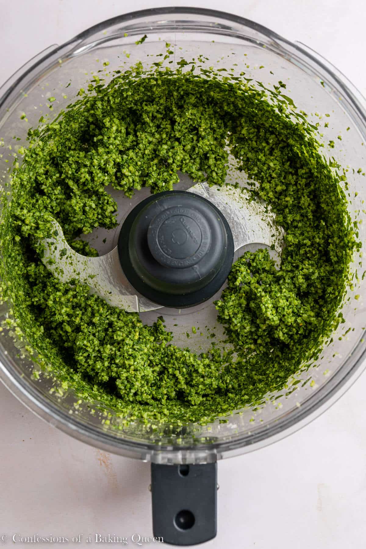 basil, pine nuts, garlic, salt, and parmsean cheese blended together in a food processor on a light surface