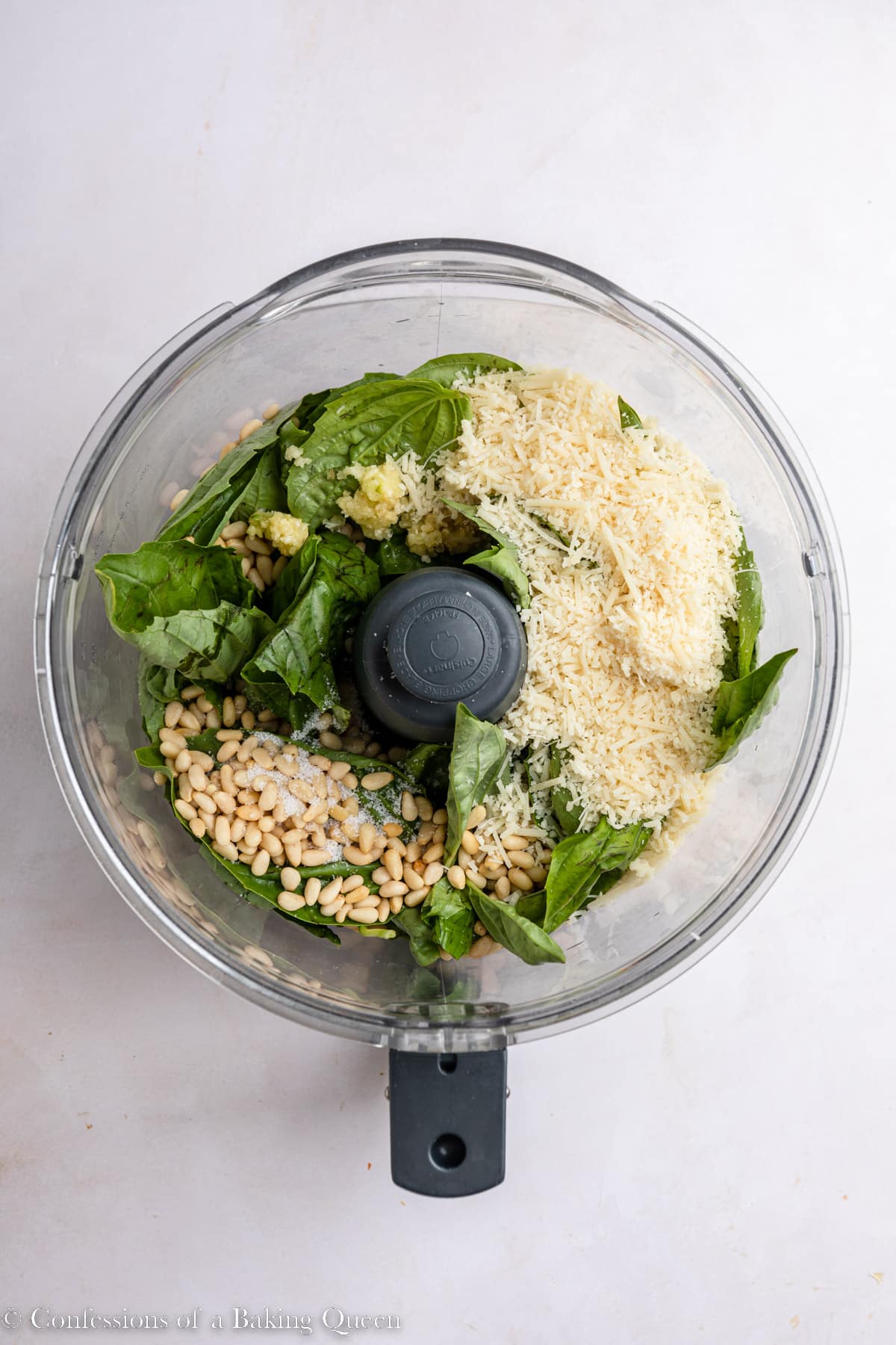 basil, pine nuts, garlic, salt, and parmsean cheese in a food processor on a light surface
