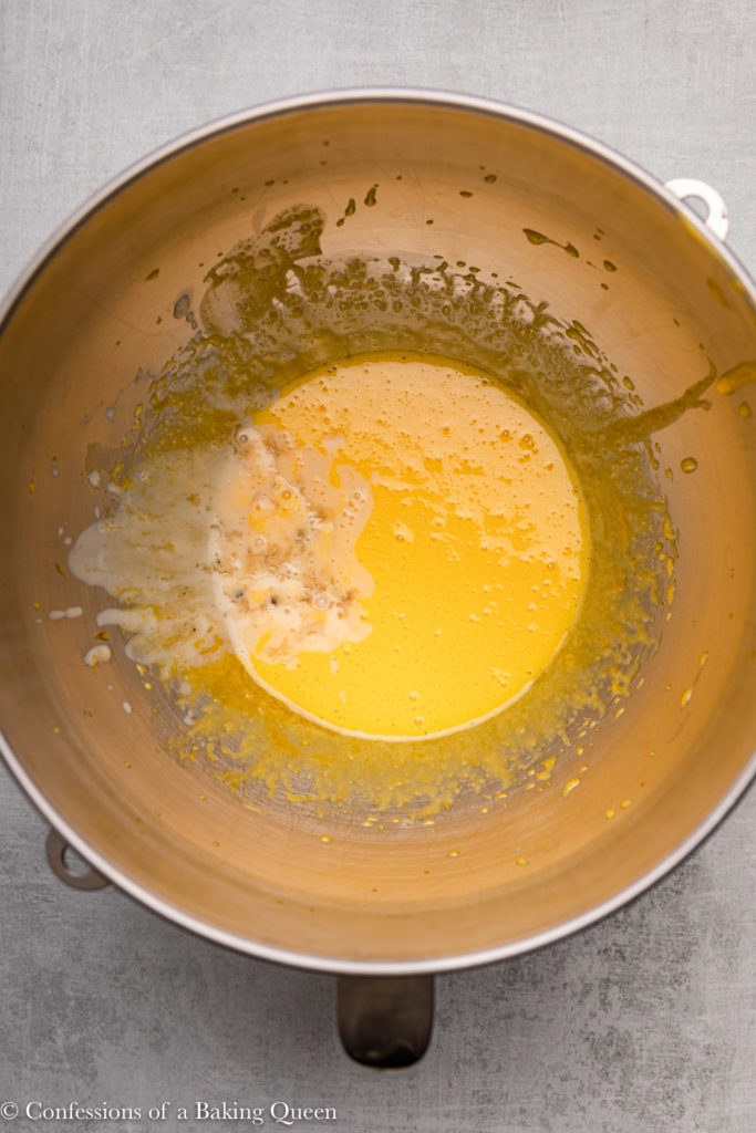 warm cream mixture added to egg mixture in a metal mixing bowl 