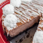 peppermint Chocolate Cheesecake baked and served on a red cake plate on a white background