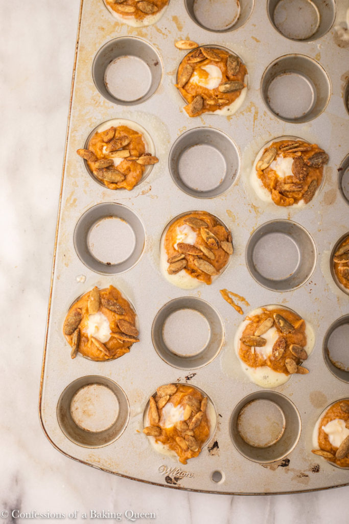 mini pumpkin cream cheese muffins in a mini muffin tray before baking