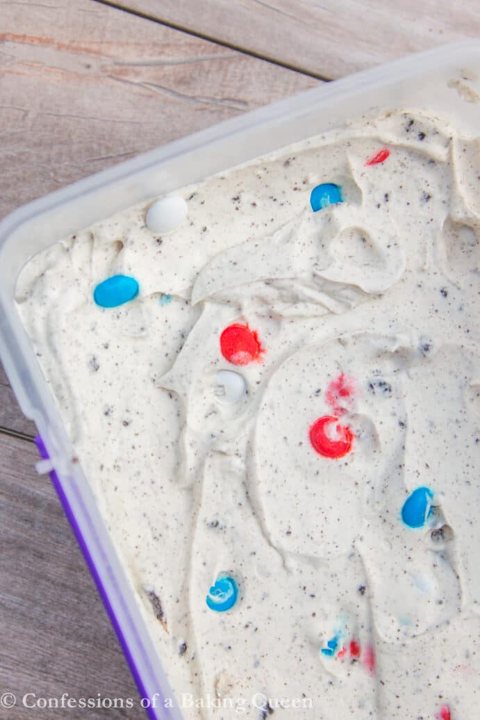 Cookies & Cream Ice Cream with m&ms in a container on a wood surface 