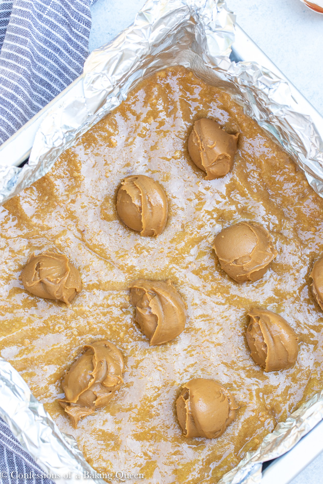 cookie butter balls on top of the crust for a cookie butter smores bar recipe