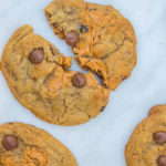 Pumpkin Chocolate Chip Cookie Butter Cookies one broken in half on white marble background