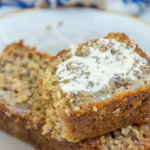Oat Flour Banana Bread with Butter on a cream plate with a white and blue linen in the background