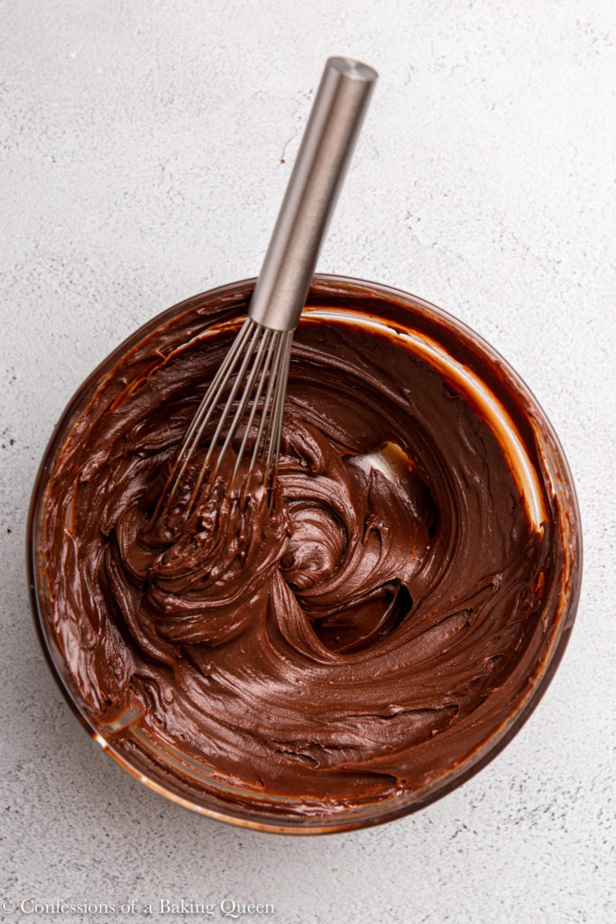 chocolate ganache and metal whisk in a glass bowl