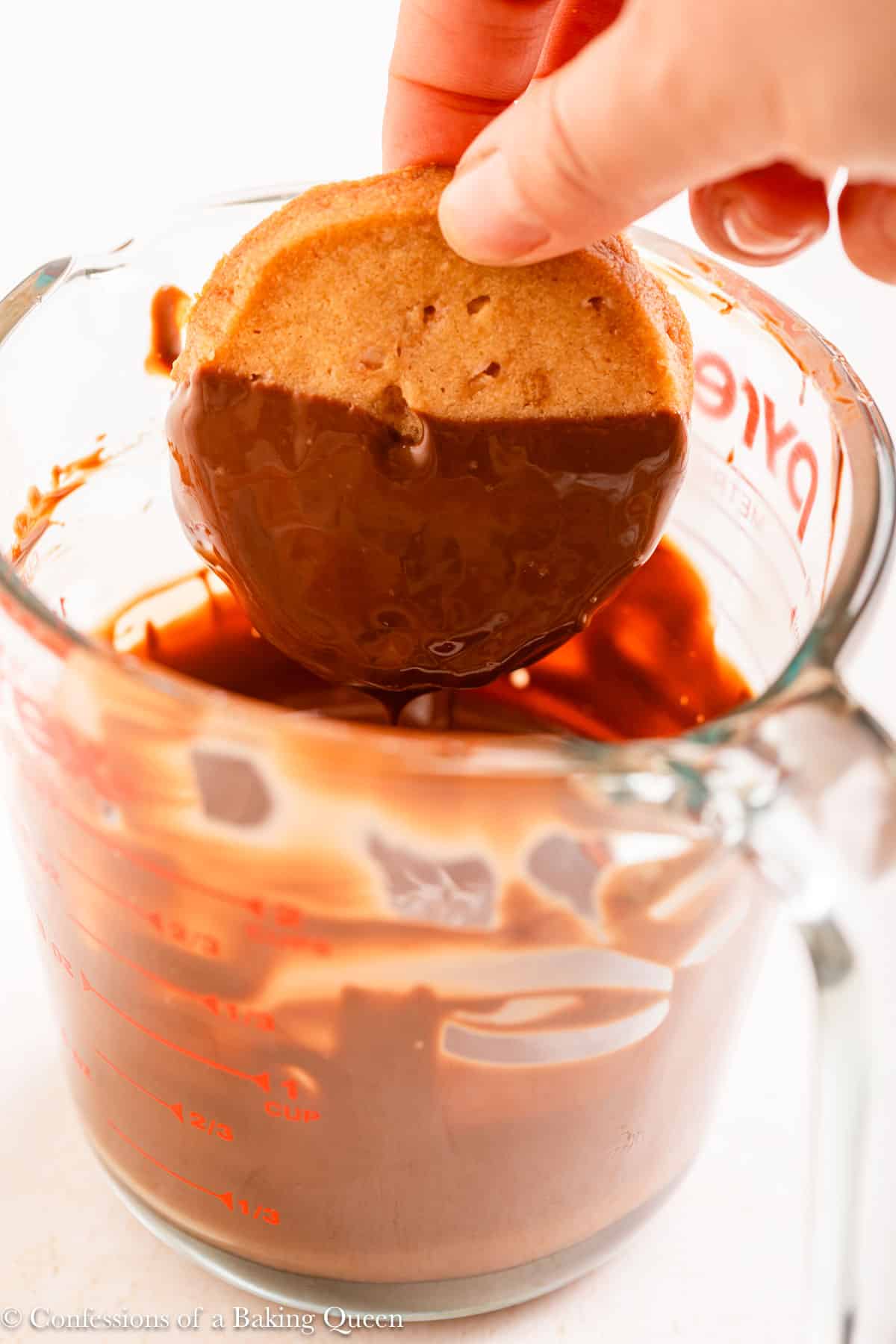 brown butter shortbread cookie dipped into chocolate in a glass pitcher