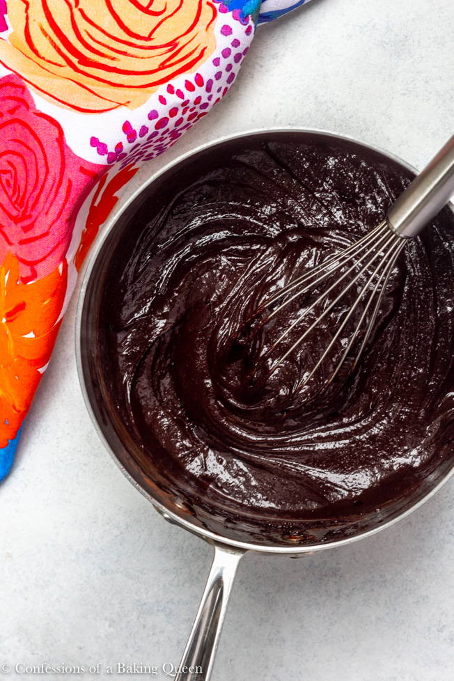 thick and dark brownie batter being mixed with a whisk