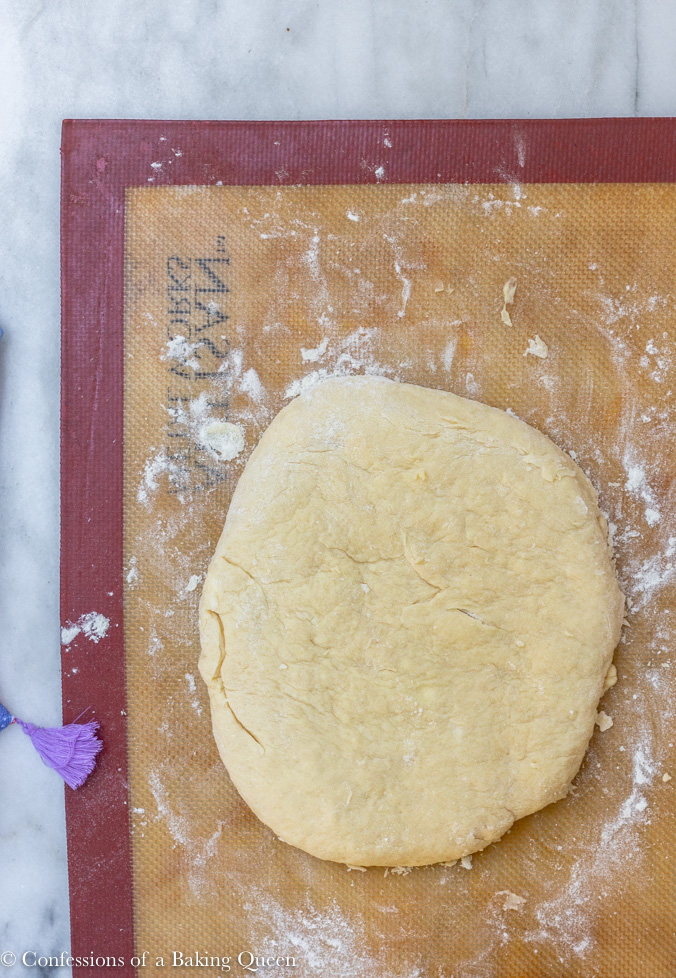 scones recipe on a silpat being shaped for cutting on a white surface