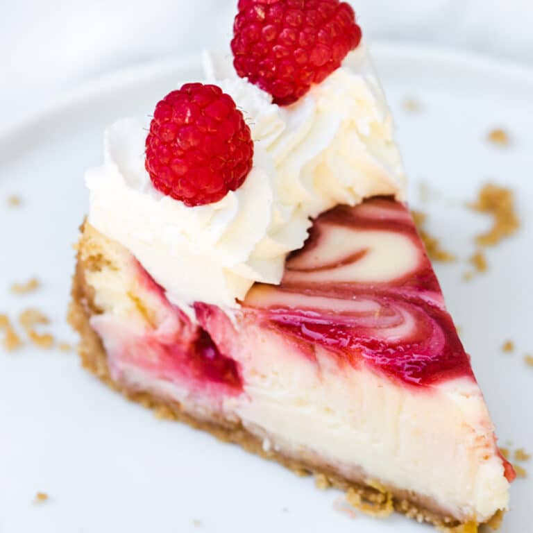 close up of raspberry swirl lemon cheesecake on a white plate
