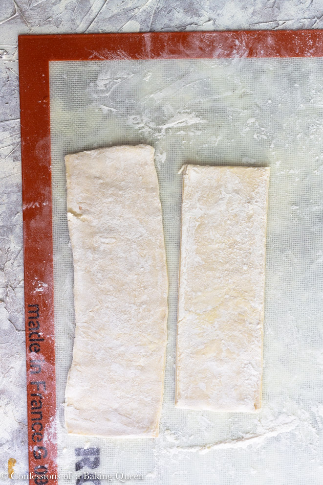 puff pastry cut and rolled out on a silpat workmat on a grey background