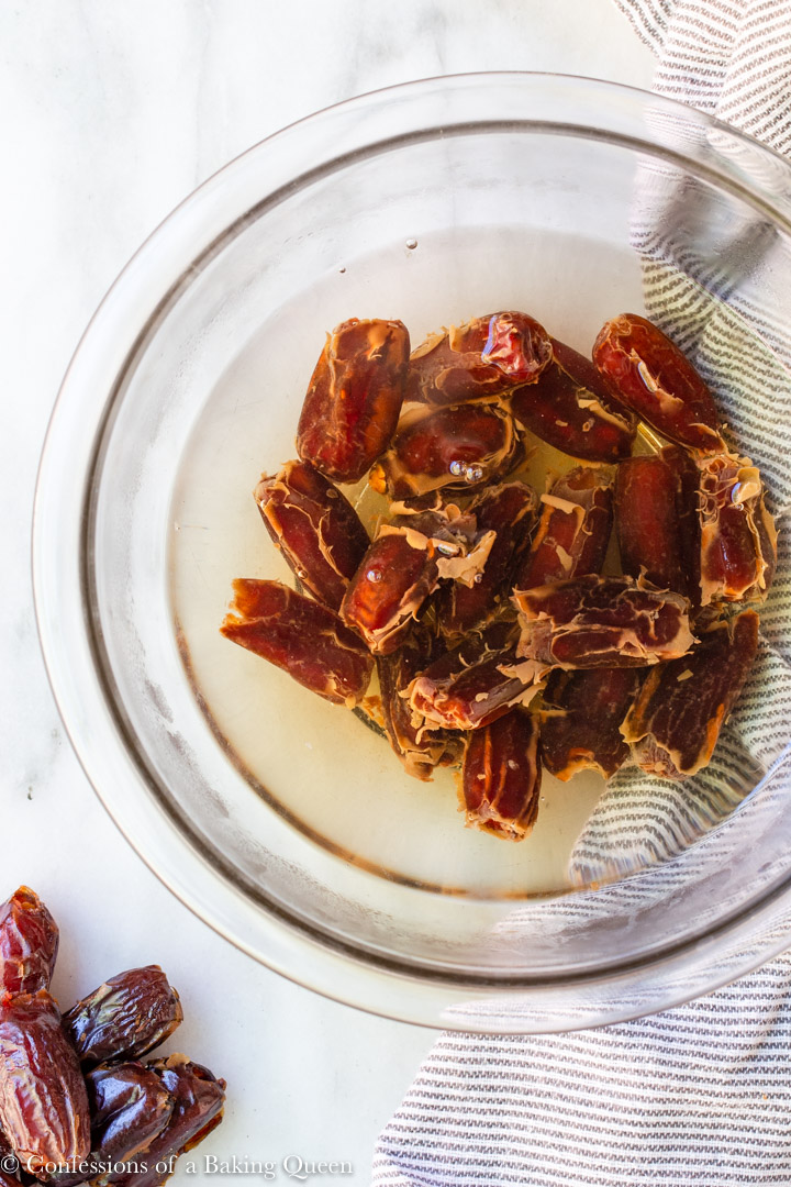 dates soaking in hot water in a glass bowl for an easy sticky toffee pudding recipe