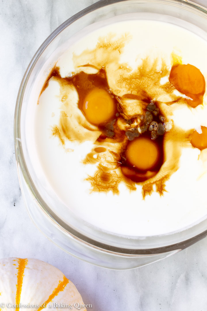 eggs, milk, cream and vanilla in a large clear bowl for a how to make pumpkin pie recipe