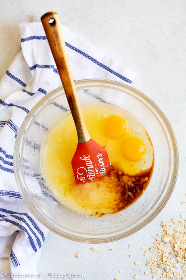 eggs and vanilla extract added to sugar and butter in an glass bowl for an oat flour banana muffin recipe