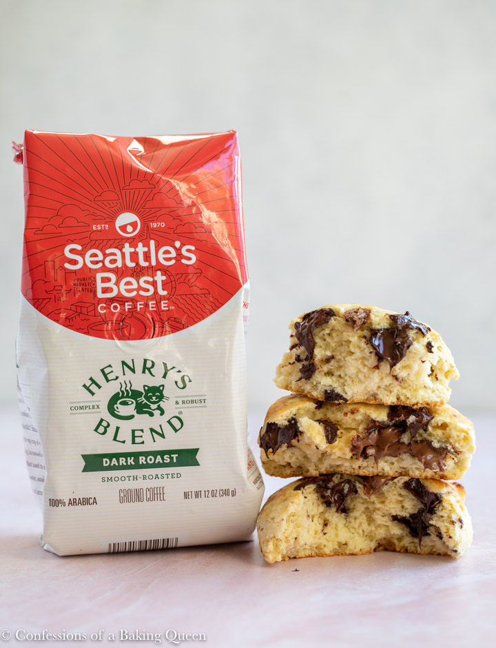bag of Seattles best coffee next to a stack of chocolate chunk scones on a pink surface