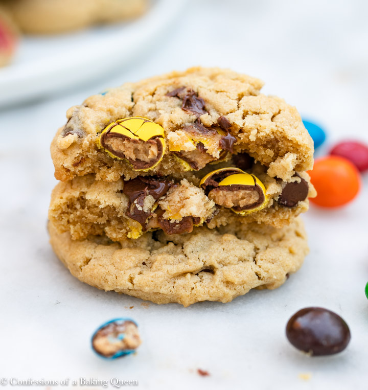 peanut butter m&M cookies stacked on a white marble surface