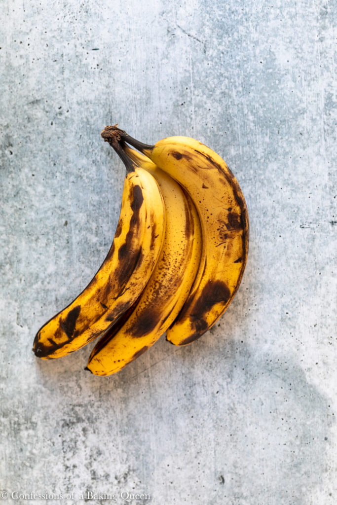 overripe bananas on a grey surface