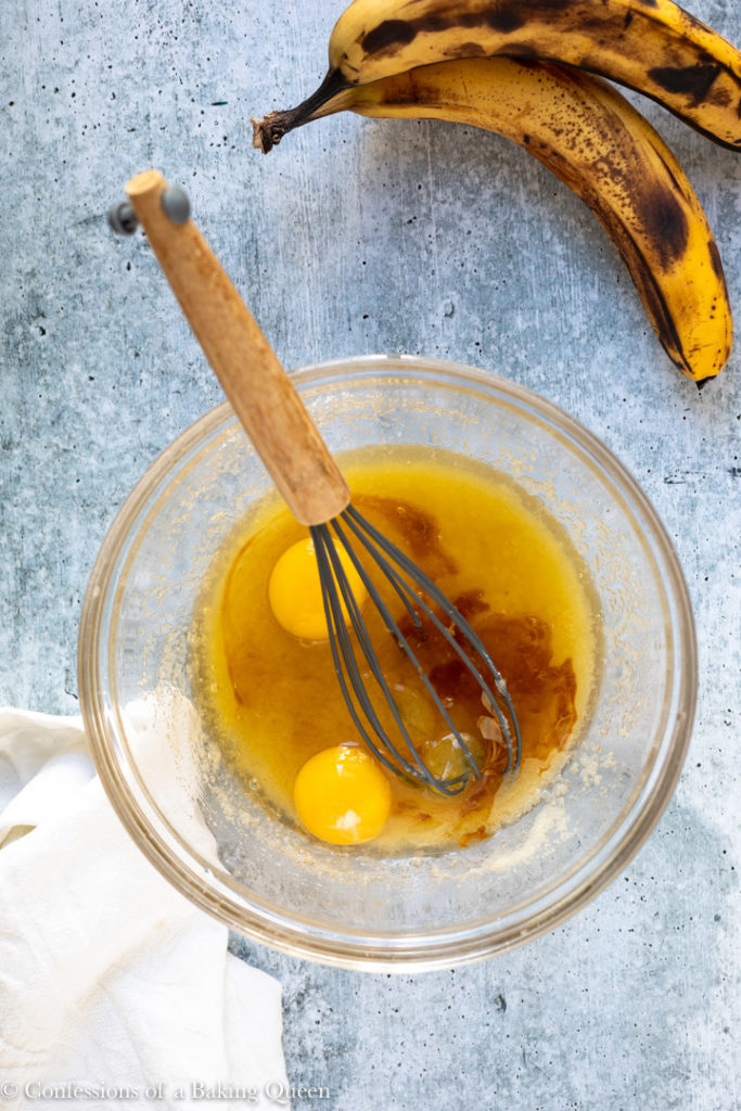 eggs and vanilla extract added to butter and sugar mixture in a glass bowl